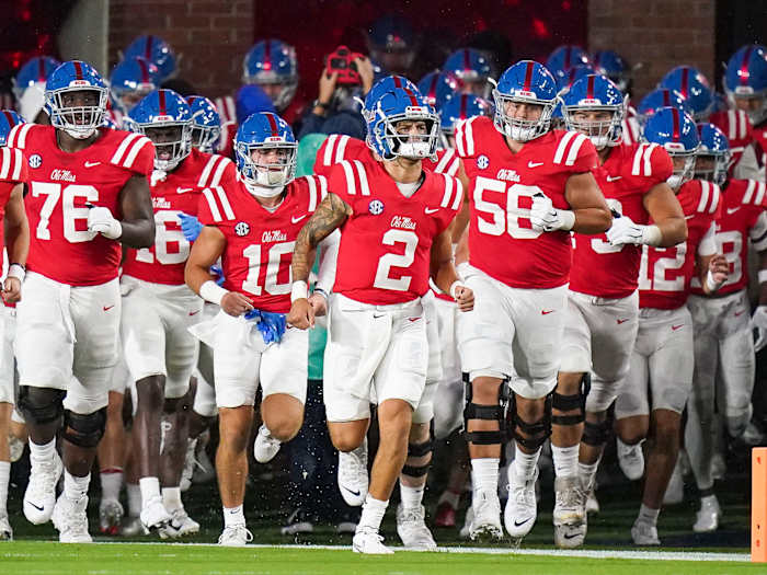 Ole Miss QB Matt Corral heads his team on to the field